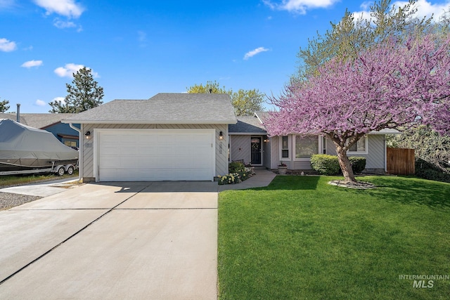 view of front of home with driveway, fence, a garage, a shingled roof, and a front yard