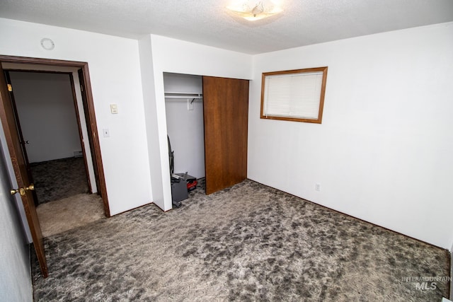 unfurnished bedroom with a closet, a textured ceiling, and carpet floors