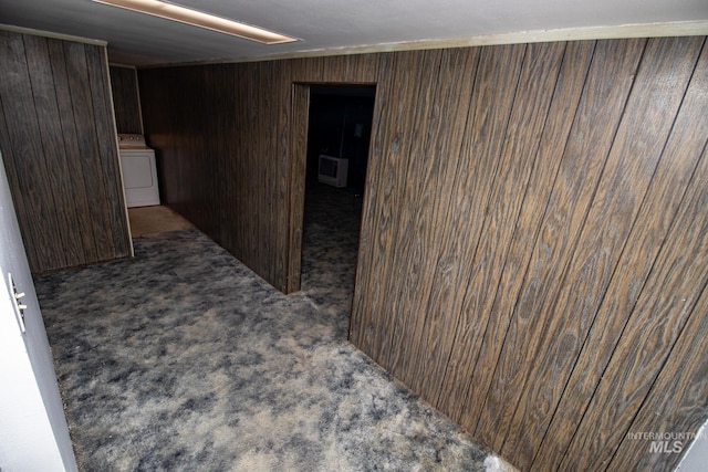 interior space featuring wooden walls, washer / dryer, and carpet floors