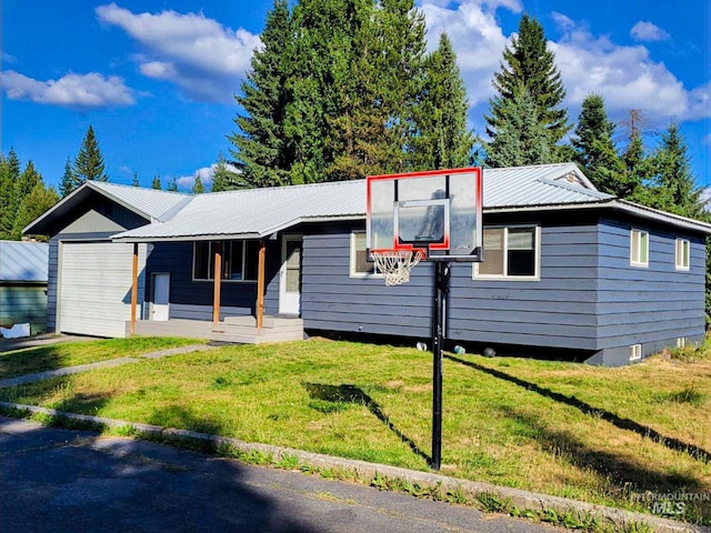 ranch-style home with metal roof, a porch, and a front lawn