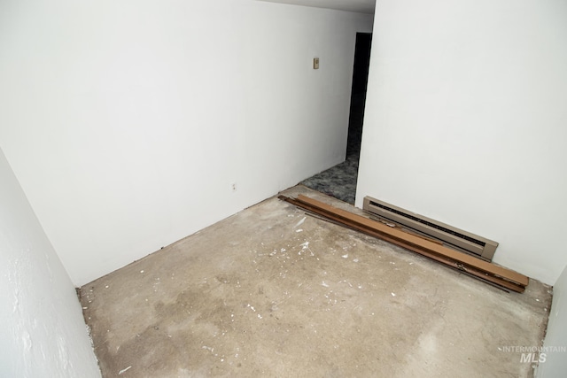 spare room featuring a baseboard radiator and unfinished concrete floors