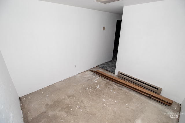 spare room featuring baseboard heating and concrete flooring