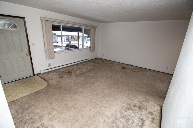 foyer entrance with baseboard heating, carpet flooring, and a textured ceiling