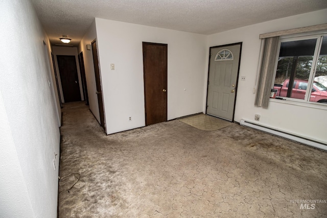 interior space with a textured ceiling and a baseboard heating unit