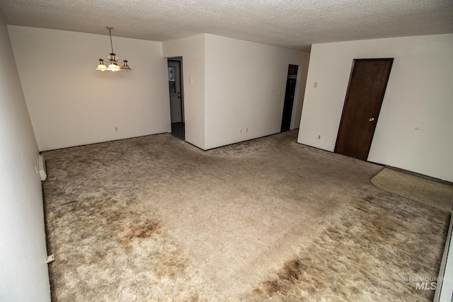 carpeted spare room with a textured ceiling