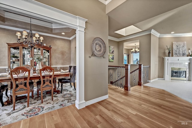 dining area with wood finished floors, crown molding, baseboards, and an inviting chandelier