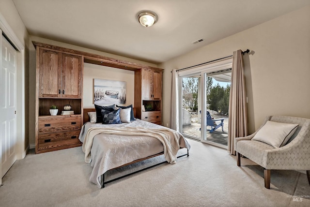 bedroom featuring access to outside, visible vents, a closet, and light colored carpet