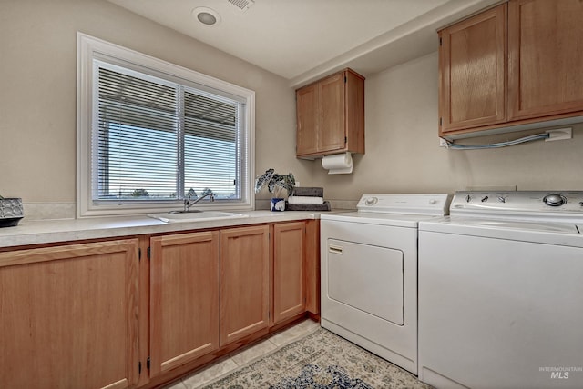 laundry area featuring cabinet space, visible vents, light tile patterned flooring, a sink, and independent washer and dryer