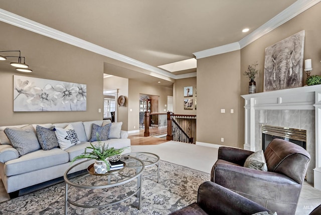 living area featuring baseboards, ornamental molding, and a tiled fireplace