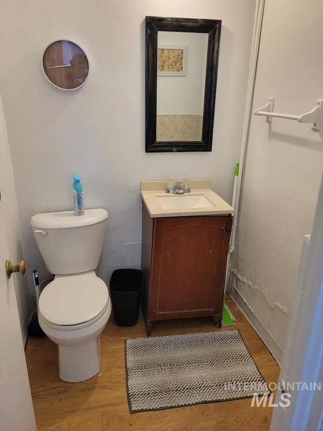 bathroom with toilet, vanity, and hardwood / wood-style flooring