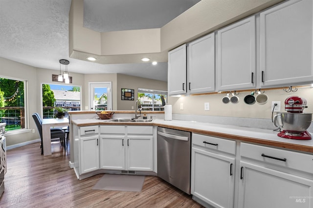 8116 Waterleaf Ave, Nampa, ID 83687 - kitchen featuring dishwasher, a sink, a peninsula, white cabinetry, and light wood finished floors