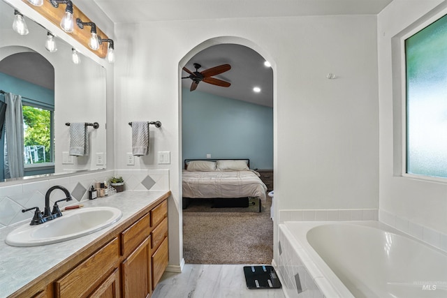 8116 Waterleaf Ave, Nampa, ID 83687 - ensuite bathroom featuring vanity, a garden tub, a ceiling fan, wood finished floors, and decorative backsplash