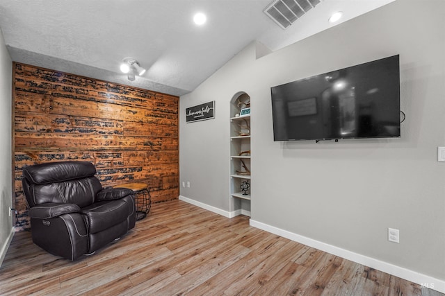 8116 Waterleaf Ave, Nampa, ID 83687 - sitting room with vaulted ceiling, baseboards, wood finished floors, wood walls, and built in features