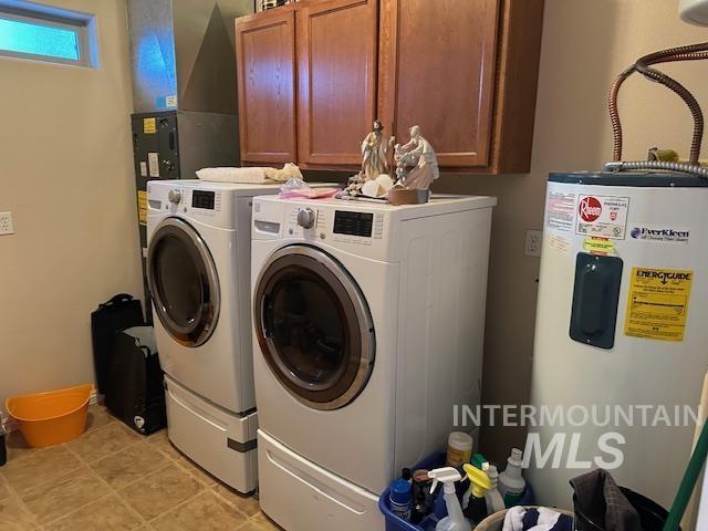 laundry room featuring washer and dryer, cabinets, light tile patterned floors, and water heater