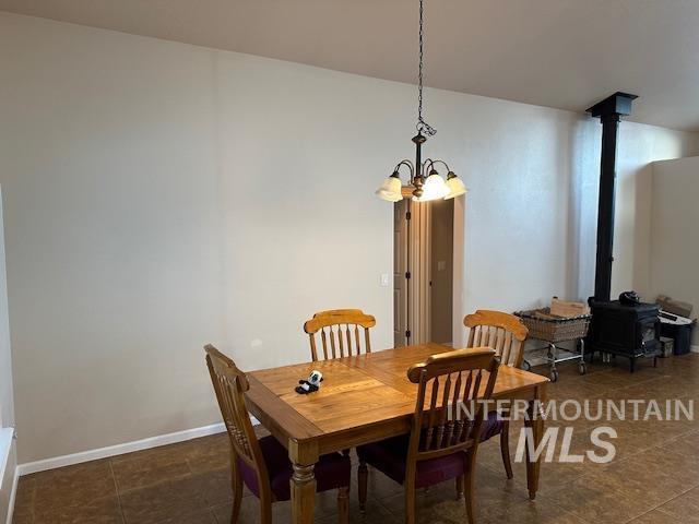 dining room with a chandelier and dark tile patterned flooring