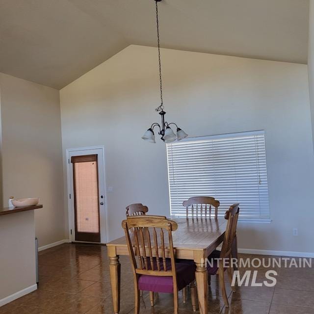 tiled dining space with high vaulted ceiling and an inviting chandelier