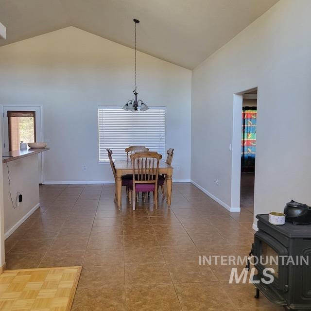 dining area featuring tile patterned floors, high vaulted ceiling, and a chandelier