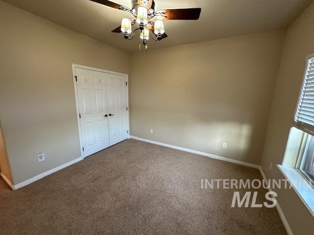 unfurnished bedroom featuring ceiling fan, carpet floors, and a closet