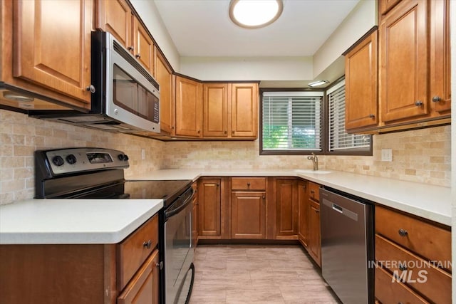 6917 W Randolph Dr, Boise, ID 83709 - kitchen featuring appliances with stainless steel finishes, brown cabinets, decorative backsplash, and light countertops