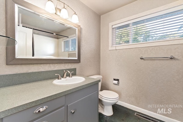 6917 W Randolph Dr, Boise, ID 83709 - bathroom featuring vanity, toilet, a textured wall, and tile patterned floors
