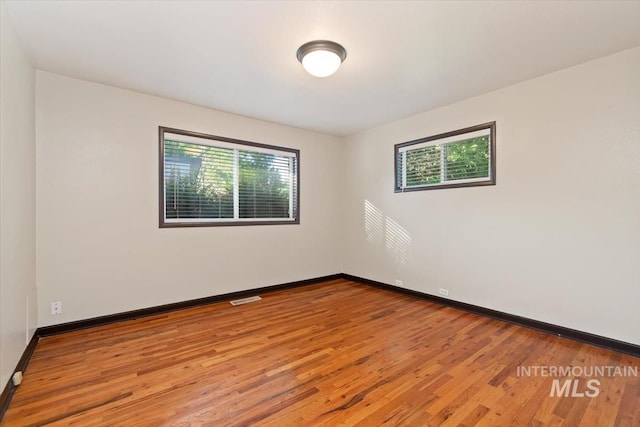 6917 W Randolph Dr, Boise, ID 83709 - empty room featuring healthy amount of natural light, light wood-style flooring, and baseboards