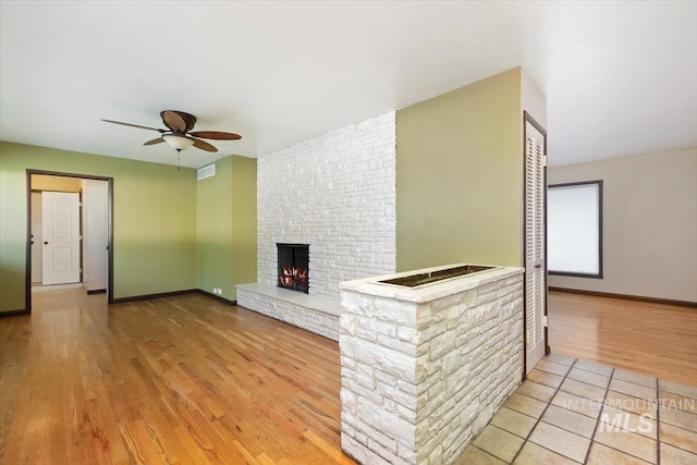 6917 W Randolph Dr, Boise, ID 83709 - unfurnished living room featuring wood finished floors, a ceiling fan, a fireplace, and baseboards