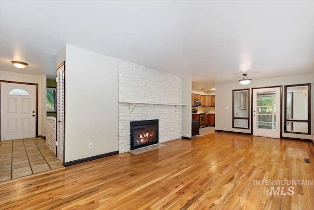 6917 W Randolph Dr, Boise, ID 83709 - unfurnished living room featuring light wood-style floors and a fireplace
