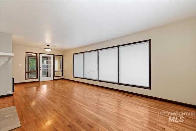 6917 W Randolph Dr, Boise, ID 83709 - unfurnished living room with baseboards and light wood-style flooring