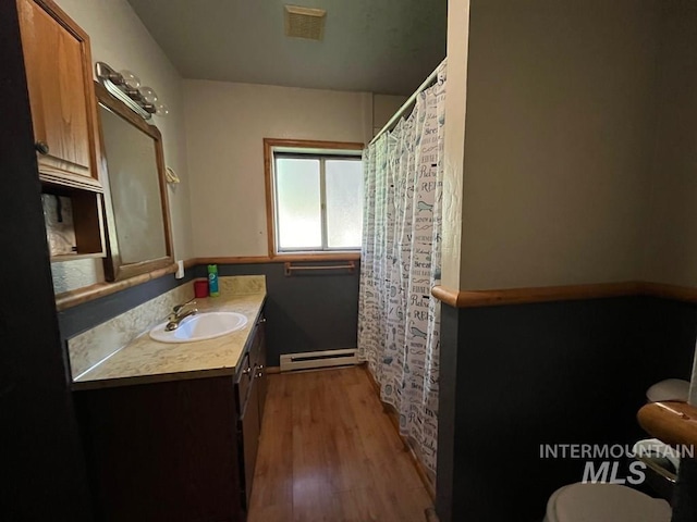 329 Forest St, Mccall, ID 83638 - full bath with baseboard heating, toilet, wood finished floors, vanity, and baseboards