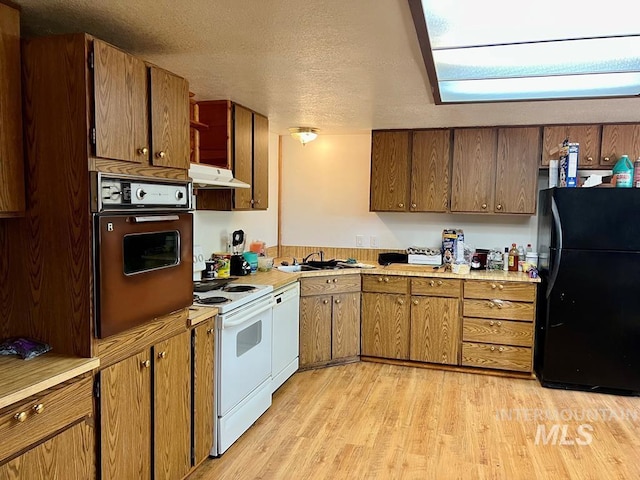 329 Forest St, Mccall, ID 83638 - kitchen with white appliances, light countertops, light wood-style floors, a sink, and a textured ceiling