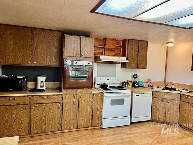 329 Forest St, Mccall, ID 83638 - kitchen with white appliances, under cabinet range hood, a sink, light countertops, and light wood-style flooring