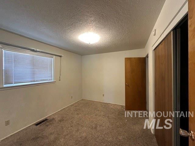 unfurnished bedroom with a closet, a textured ceiling, and carpet flooring