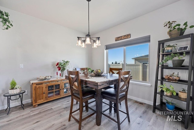 dining room with a chandelier and light hardwood / wood-style flooring