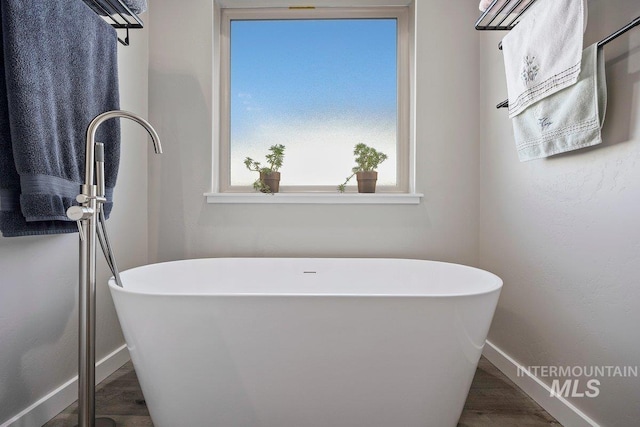 bathroom featuring hardwood / wood-style flooring and a bath