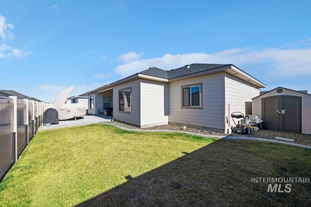 rear view of house featuring a storage shed and a yard