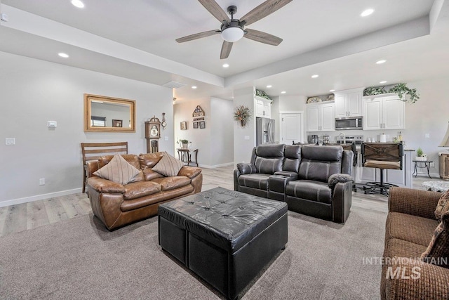 living room with ceiling fan and light wood-type flooring