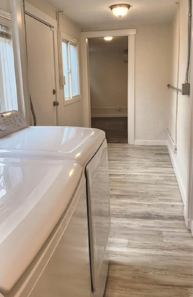 3377 W Nez Perce St, Boise, ID 83705 - clothes washing area with light wood-type flooring, washing machine and clothes dryer, baseboards, and laundry area
