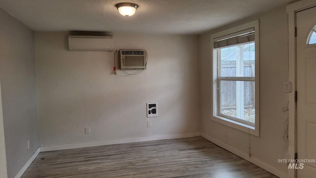3377 W Nez Perce St, Boise, ID 83705 - unfurnished dining area featuring wood finished floors, an AC wall unit, a healthy amount of sunlight, and a wall mounted air conditioner