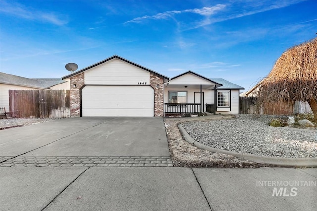 ranch-style house with a garage, driveway, brick siding, and fence