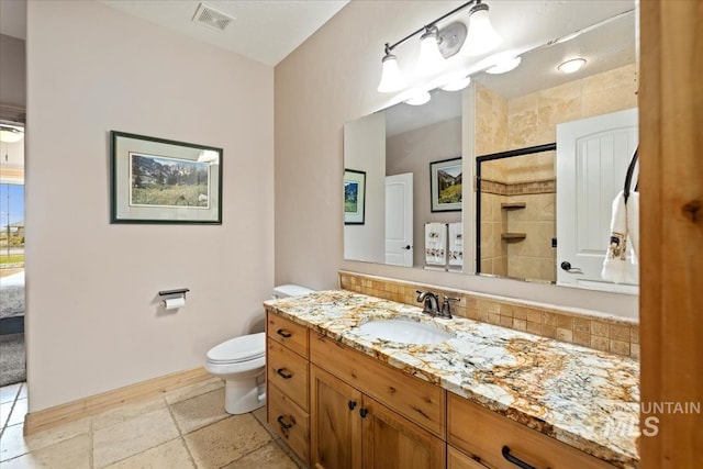 ensuite bathroom with visible vents, vanity, toilet, baseboards, and backsplash