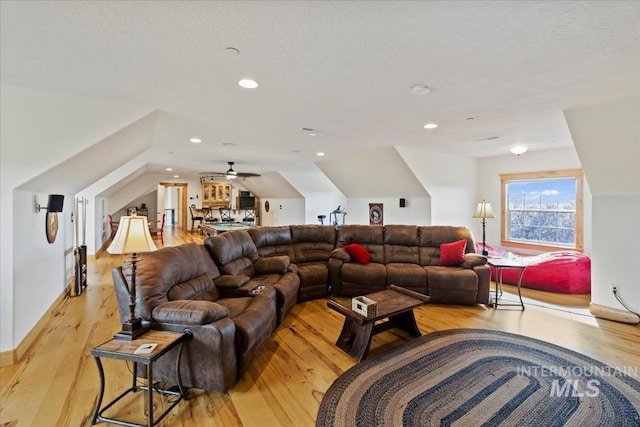 living area with recessed lighting, vaulted ceiling, and light wood finished floors
