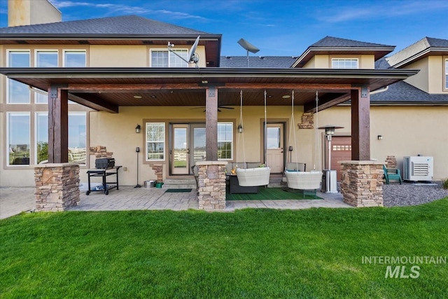 back of property featuring ac unit, a patio area, an outdoor hangout area, a yard, and stucco siding