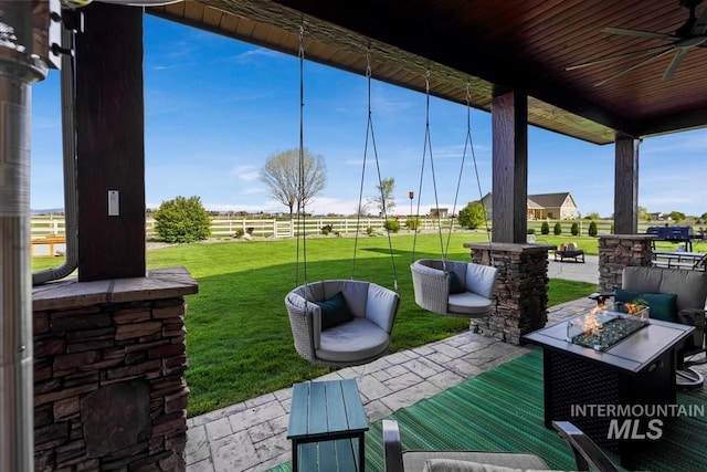 view of patio with ceiling fan and a fire pit
