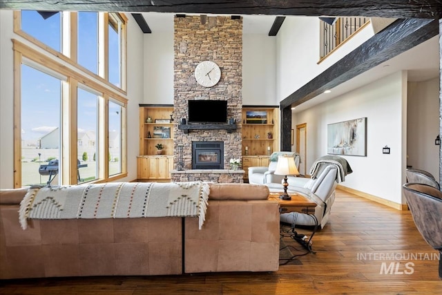 living area featuring plenty of natural light, a high ceiling, and hardwood / wood-style floors