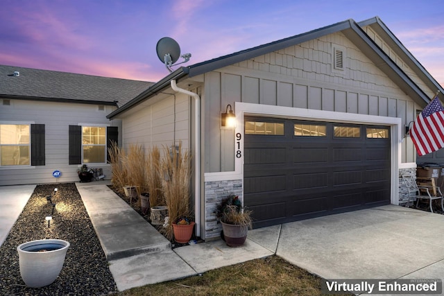 918 S Beaver Creek Way, Emmett, ID 83617 - property exterior at dusk featuring board and batten siding, stone siding, an attached garage, and concrete driveway