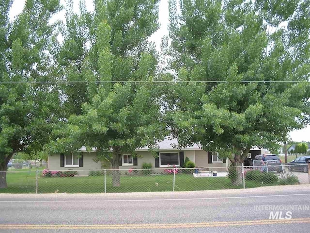ranch-style house with stucco siding, a front lawn, and a fenced front yard