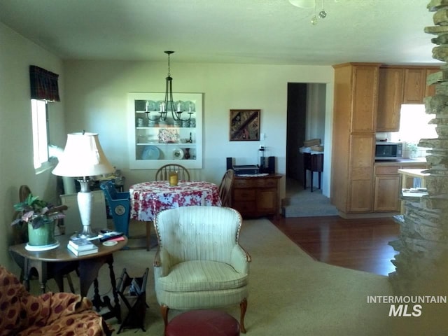 living area featuring plenty of natural light, a chandelier, and wood finished floors