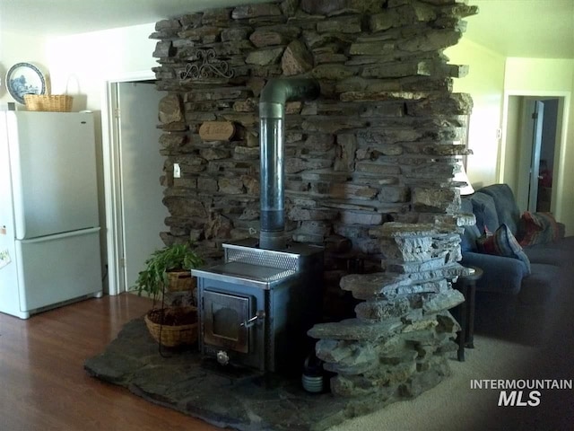 interior details featuring a wood stove, hardwood / wood-style flooring, and white refrigerator