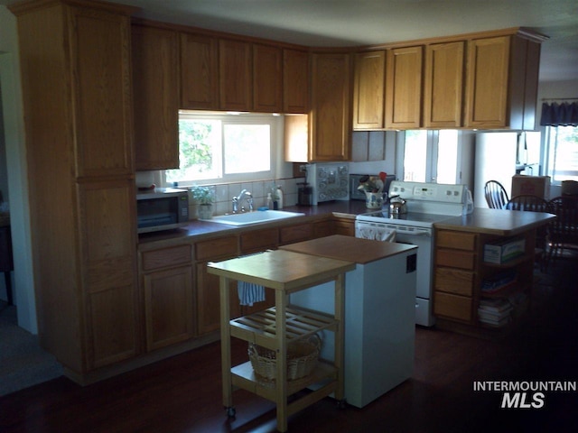 kitchen with sink, dark hardwood / wood-style flooring, a center island, and white electric stove