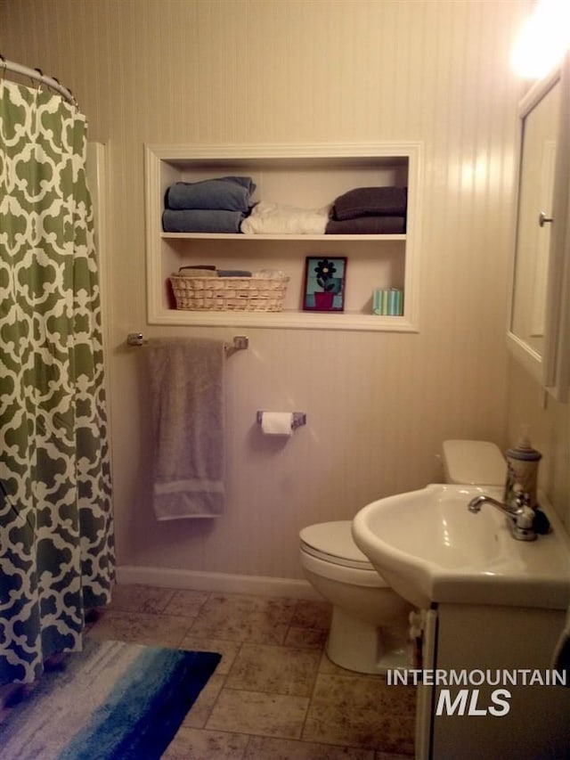 bathroom with a shower with shower curtain, vanity, baseboards, and toilet